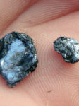 Nærbilde av det gråglinsende mineralet molybdenglans.